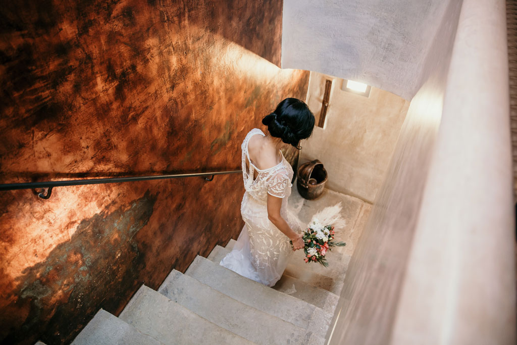 Anja pavlova läuft die Treppe hinab mit Brautstrauß und brautkleid 