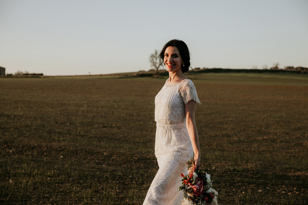 Anja pavlova trägt ein brautkleid von Tilda knopf aus berlin und trägt einen Brautstrauß beim Sonnenuntergang in Barcelona 