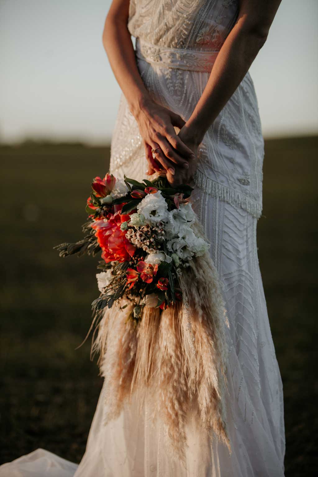 Anja pavlova trägt ein brautkleid von Tilda knopf aus berlin und trägt einen Brautstrauß beim Sonnenuntergang in Barcelona 