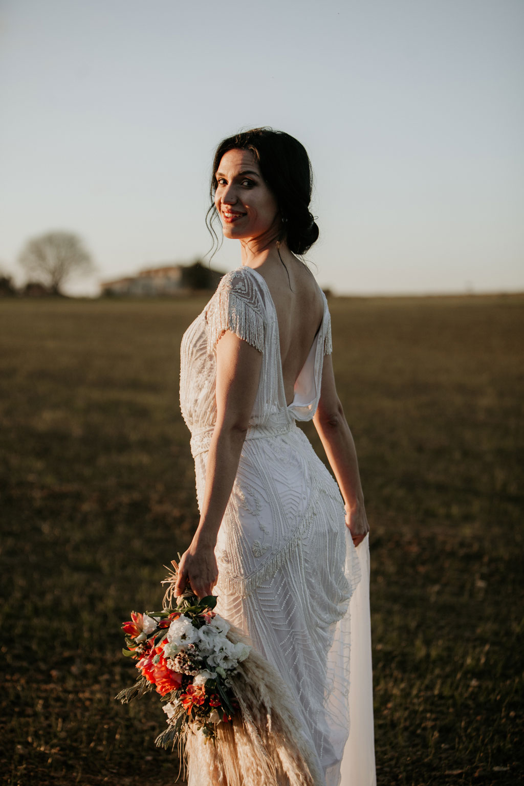 Anja pavlova trägt ein brautkleid von Tilda knopf aus berlin und trägt einen Brautstrauß beim Sonnenuntergang in Barcelona 