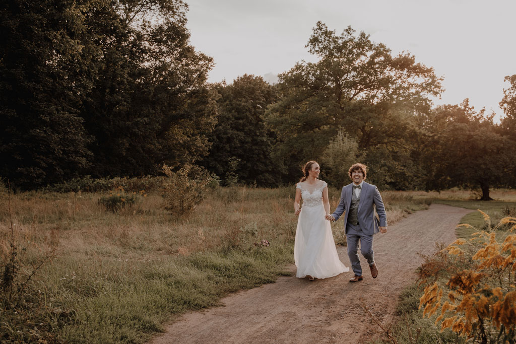 Afterwedding Shooting in der Wuhlheide 2 afterweddingsfotos in berlin wuhlheide Fotograf berlin Hochzeitsfotograf berlin Brautpaar auf Feld beim springen und rennen Sonnenuntergang Verlobungsfotos Hochzeitsfotografie