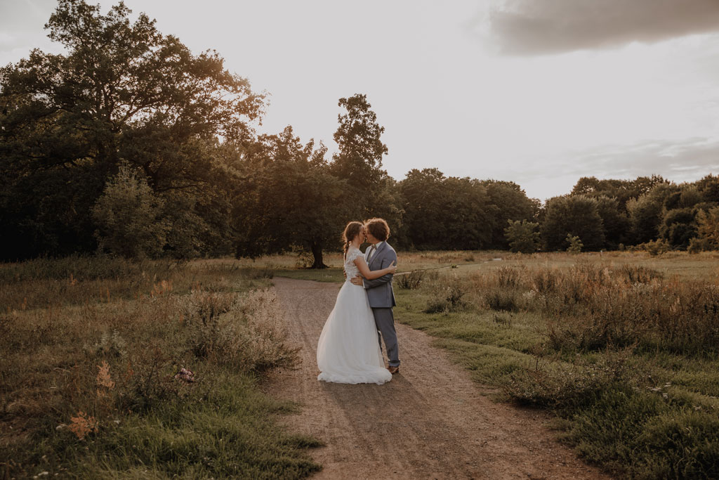 Afterwedding Shooting in der Wuhlheide 4 afterweddingsfotos in berlin wuhlheide Fotograf berlin Hochzeitsfotograf berlin Brautpaar auf Feld beim springen und rennen Sonnenuntergang Verlobungsfotos Hochzeitsfotografie