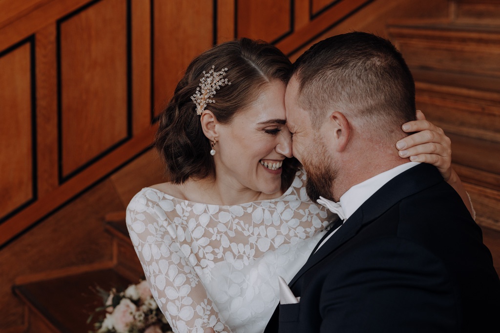 Hochzeit im Standesamt berlin treptow köpenick denkmalgüschtztes rathaus beliebte Filmkulisse für film heiraten Standesamt trauung in berlin Portraits auf Holztreppe Wendeltreppe Paarfotos in berlin hochzeitsfotograf berlin