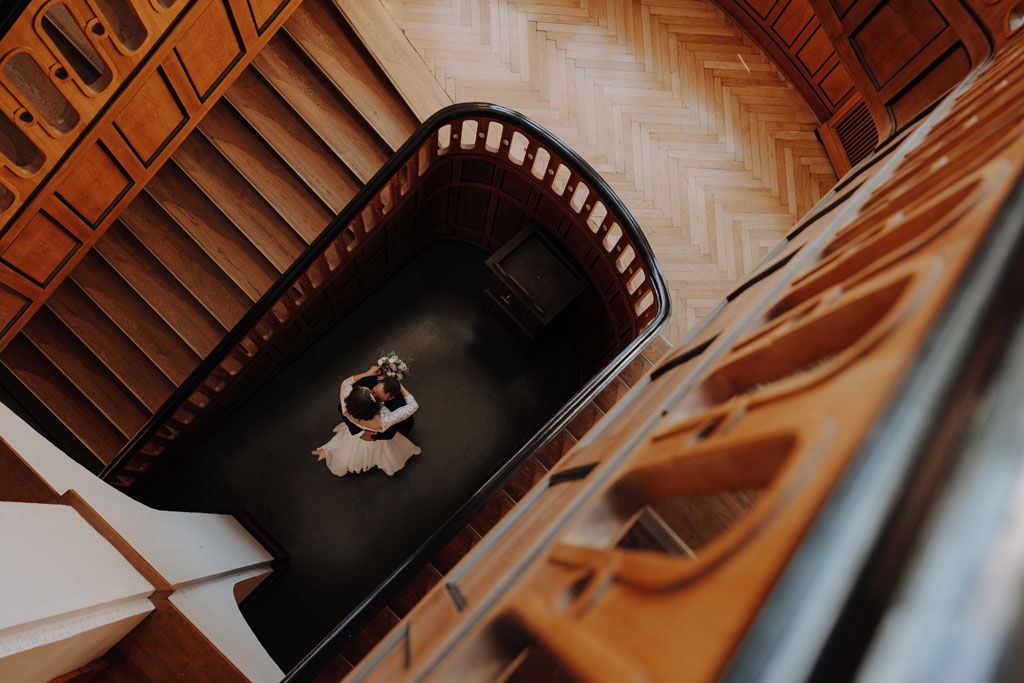 Hochzeit im Standesamt berlin treptow köpenick denkmalgüschtztes rathaus beliebte Filmkulisse für film heiraten Standesamt trauung in berlin Portraits auf Holztreppe Wendeltreppe Paarfotos in berlin hochzeitsfotograf berlin