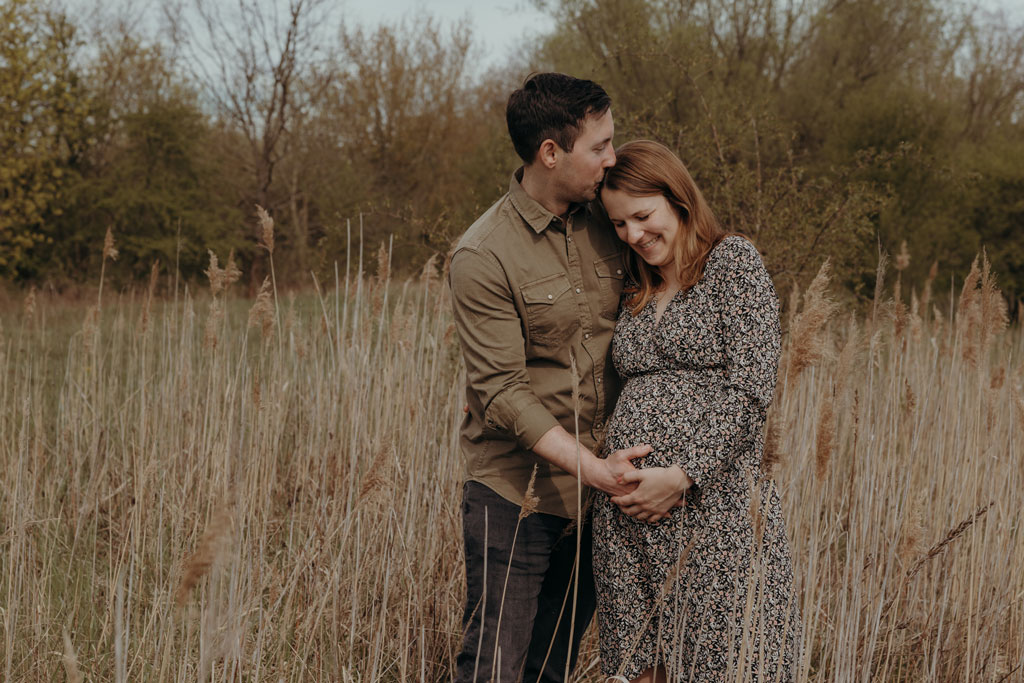 babybauchfotos in Berlin Karlshorst auf einem Feld im biesenhorster Sand Bilder in Bewegung Schwangerschaftsfotos babybauchshooting Paarfotos töne braun beige