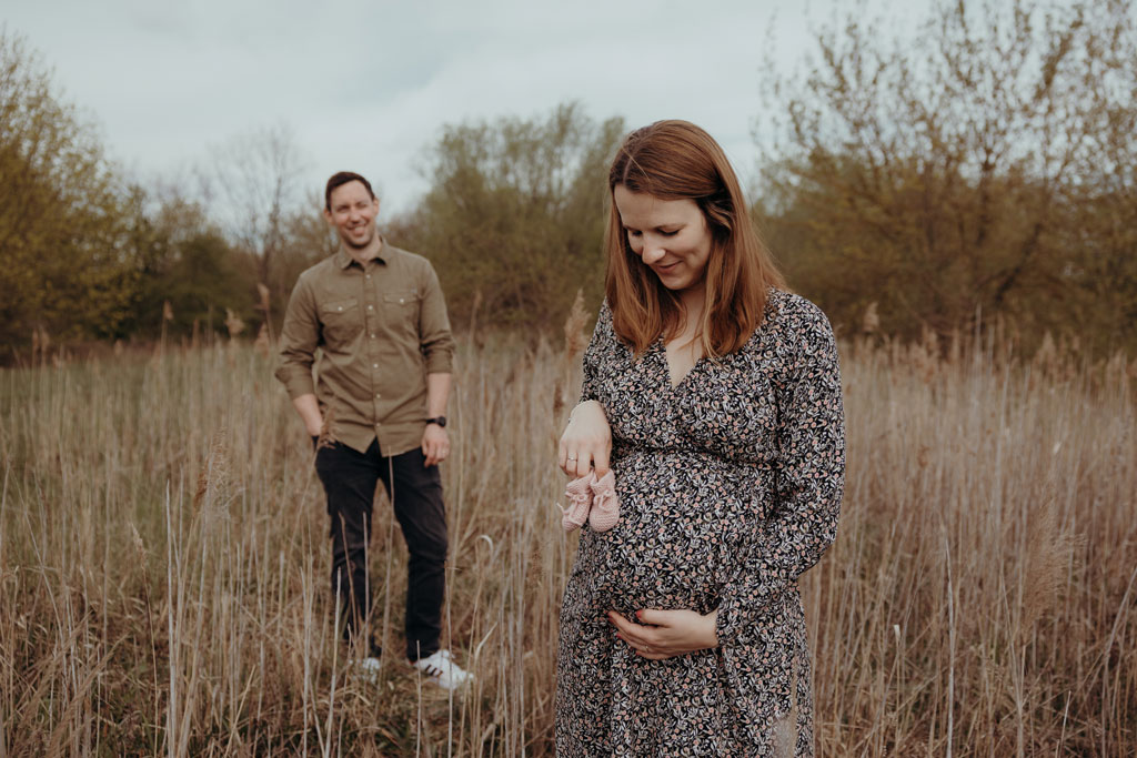 babybauchfotos in Berlin Karlshorst auf einem Feld im biesenhorster Sand Bilder in Bewegung Schwangerschaftsfotos babybauchshooting Paarfotos töne braun beige