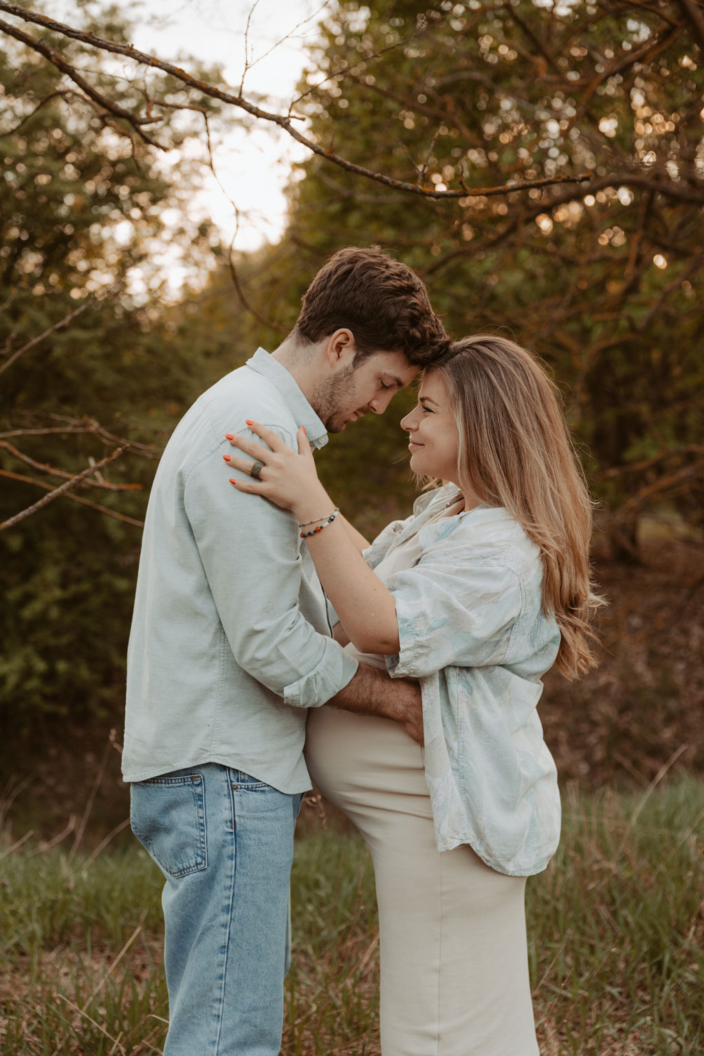 Babybauchfotos 9 Babybauchfotos im grünen auf einem Feld und in einem Wald in berlin Karlshorst. fotografiert mit einem paar mit einem Babybauch und einer Fotografin aus berlin, die auch Bilder in ganz Deutschland von Familien macht. Grün und viel Natur. Kuschelige, natürliche Fotos zu Zweit. Familienfotos.