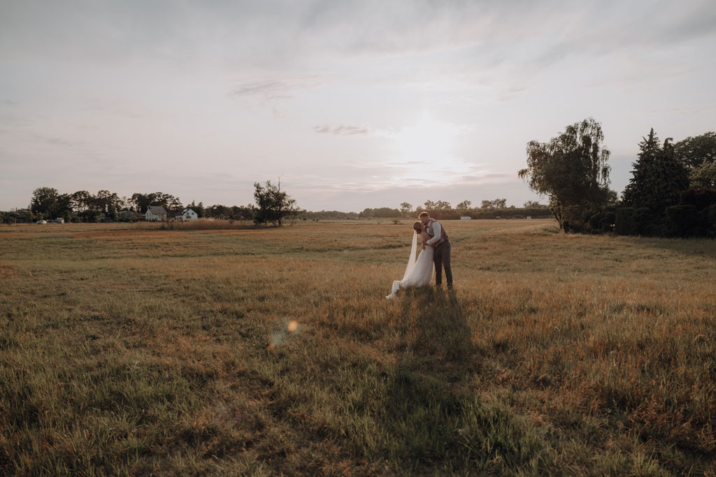 hochzeitsfotograf im farmhouse in wandlitz in Brandenburg bei berlin hochzeitslocation in der Natur festivalwedding Festivalhochzeit Fotograf fotografiert hochzeit trauung freie trauung waldkapelle paarfotos feld sonnuntergang