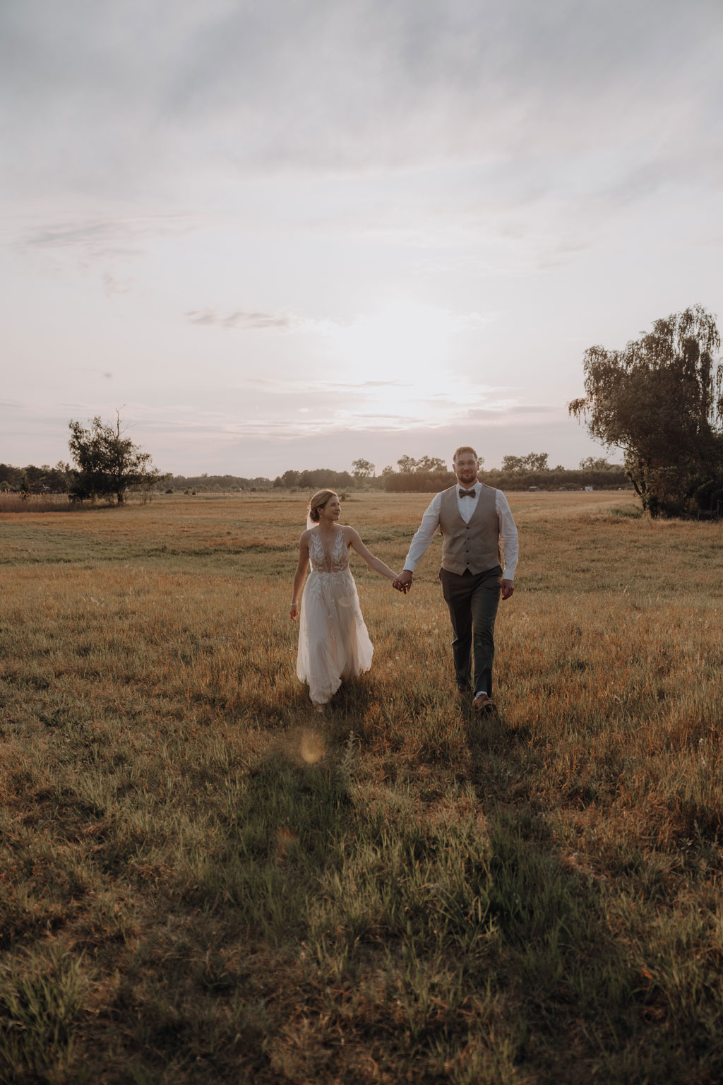 hochzeitsfotograf im farmhouse in wandlitz in Brandenburg bei berlin hochzeitslocation in der Natur festivalwedding Festivalhochzeit Fotograf fotografiert hochzeit trauung freie trauung waldkapelle paarfotos feld sonnuntergang