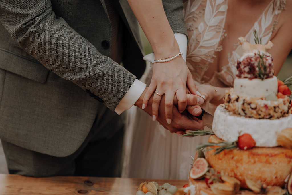 hochzeitsfotograf im farmhouse in wandlitz in Brandenburg bei berlin hochzeitslocation in der Natur festivalwedding Festivalhochzeit Fotograf fotografiert hochzeit trauung freie trauung waldkapelle kuchen käse anschnitt hochzeitstorte