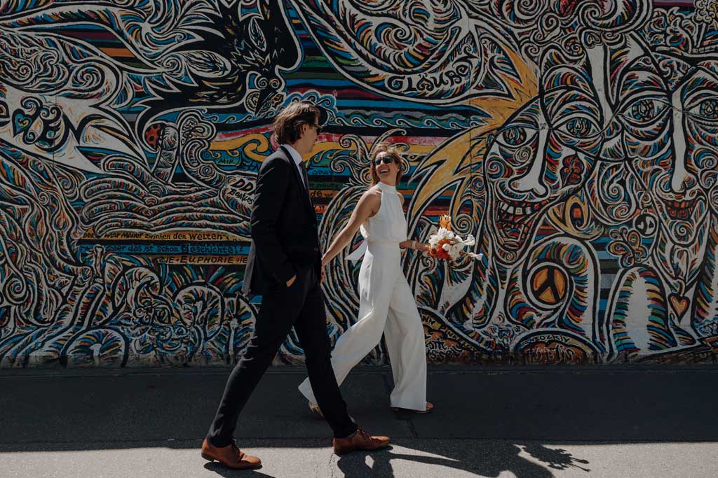 Hochzeitsfeier in berlin und standesamtliche trauung in Mitte nähe des Fernsehturmes und dann ging es zur Eastside Gallery in den park für einen Sektempfang und dort haben wir Hochzeitsbilder und Hochzeitsfotos gemacht vor der oberbaumbrücke. als Hochzeitsfotografin in berlin hatte ich mit diesem paar, die viel auf Festivals unterwegs sind, je menge spaß.